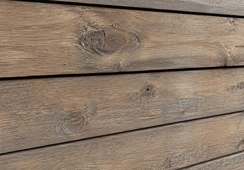 Woodtone RusticSeries lap siding in a weathered driftwood-brown woodgrain finish